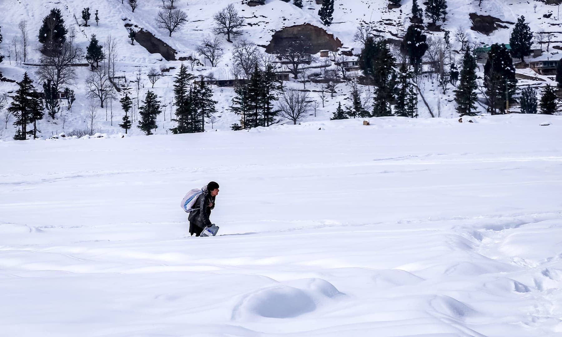 Local man walking in snow in Kalam by Fazal Khaliq